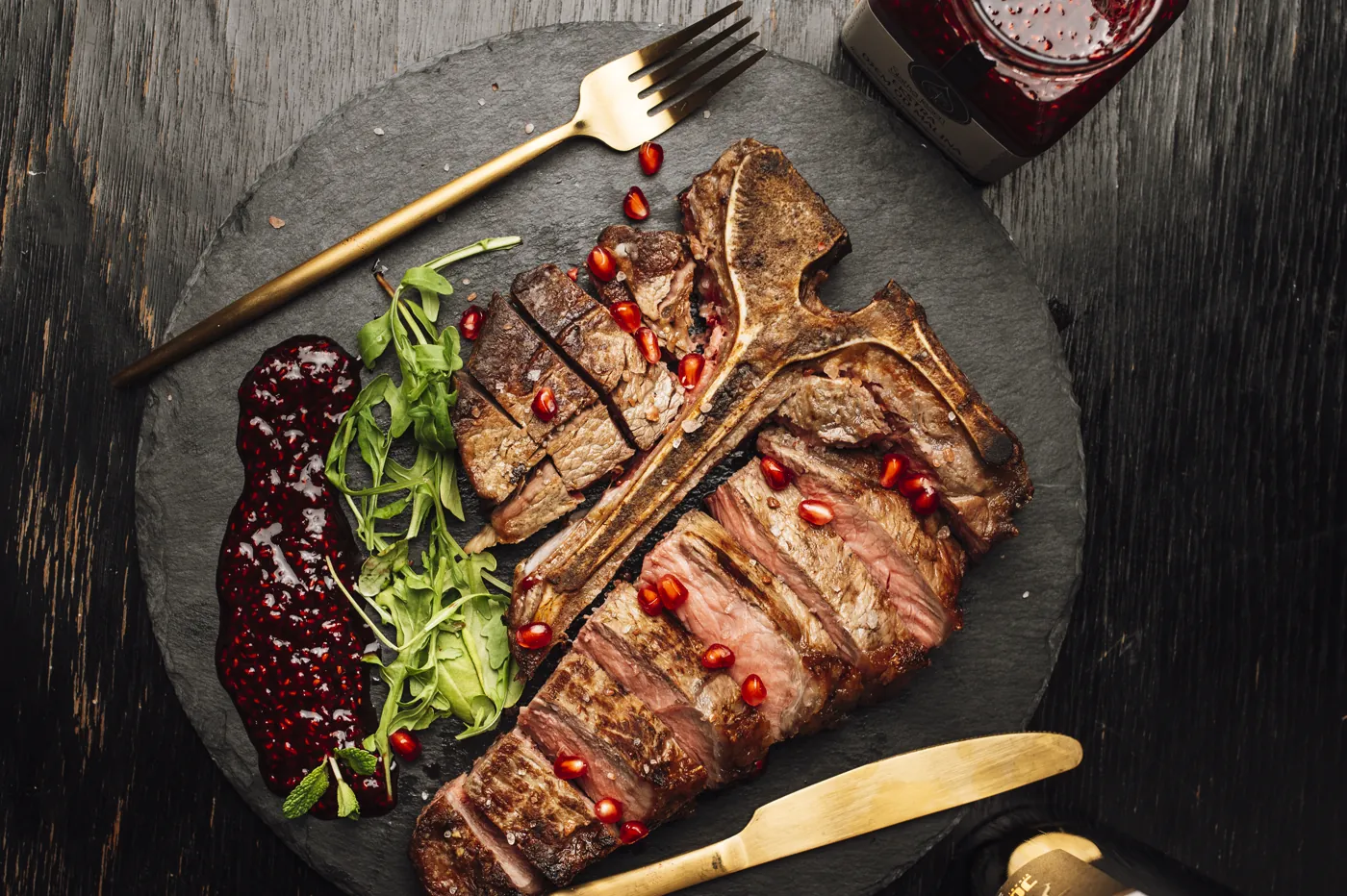 Sliced grilled steak served with greens and sauce
