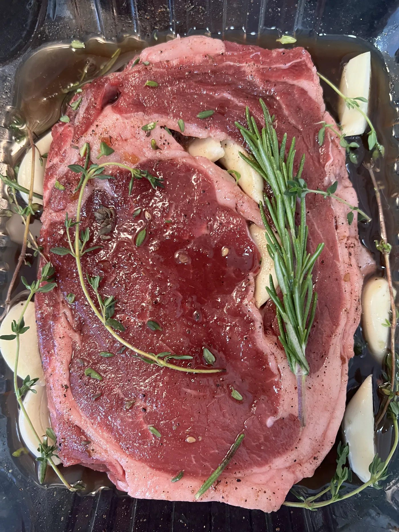 Raw ribeye steaks with herbs